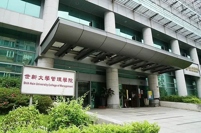 管理學院的學生們穿著正裝，在課堂上進行商業個案的互動討論